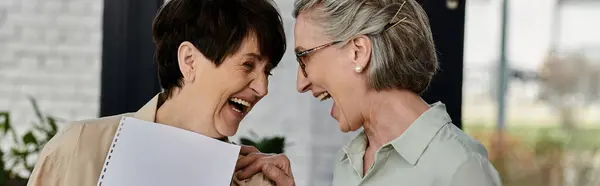 Dos mujeres maduras y hermosas están en una oficina, exudando profesionalismo y unidad. - foto de stock