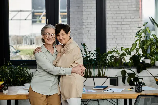 Dos mujeres maduras de pie juntas en unidad y apoyo. - foto de stock
