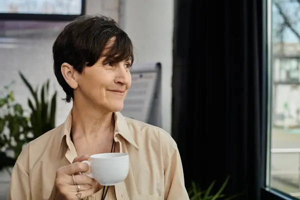 Woman savoring coffee at window. — Stock Photo