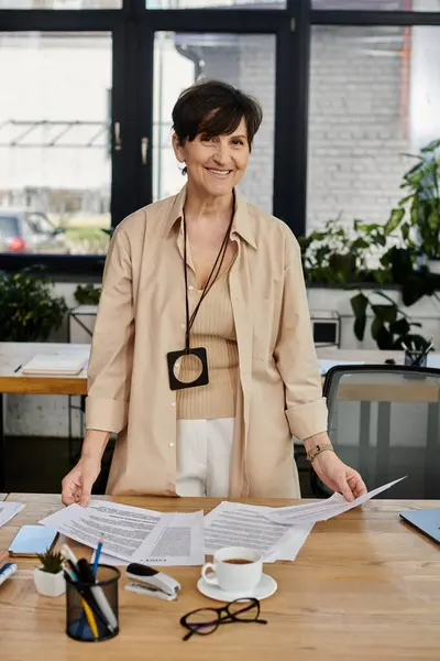 A woman standing in front of a table covered with papers. — Stock Photo