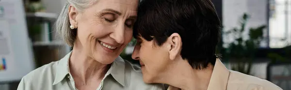 Two women sharing a tender hug in office. — Stock Photo