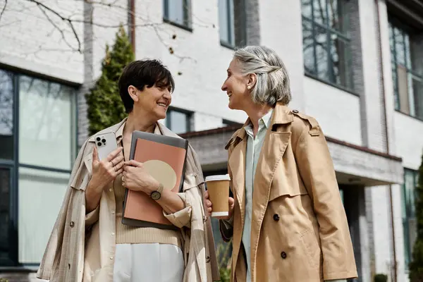 Zwei reife schöne Frauen stehen vereint bereit, den Tag gemeinsam zu meistern. — Stockfoto