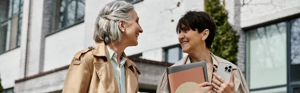 Two mature, beautiful women walking together. — Stock Photo
