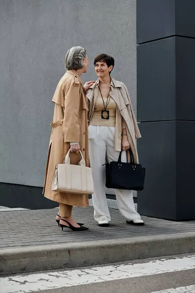 Two women engage in conversation on a city sidewalk. — Stock Photo
