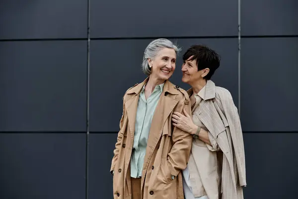 Two elegant women pose outside a building. — Stock Photo
