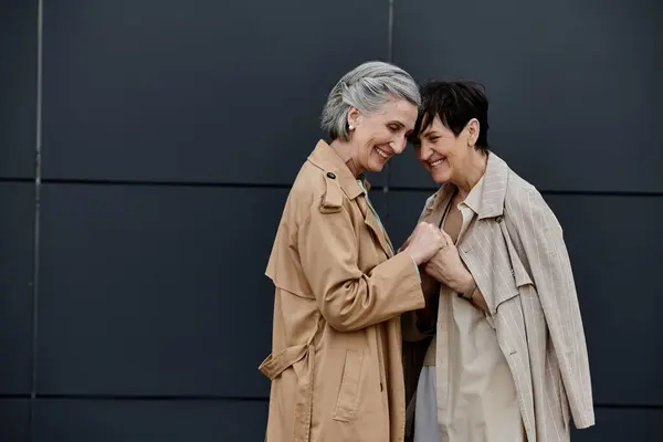 Two mature women, a beautiful lesbian couple, walk together to their office. — Stock Photo