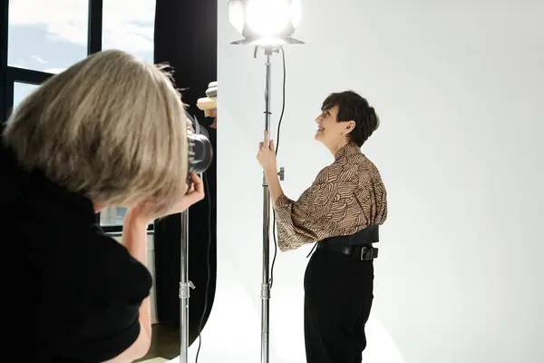 A middle-aged woman captures herself in the mirror, a tender moment of self-expression and self-love in a photo studio. — Stock Photo