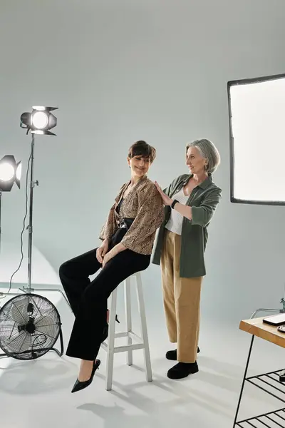 Middle-aged lesbian couple in a photo studio, behind the camera process — Stock Photo