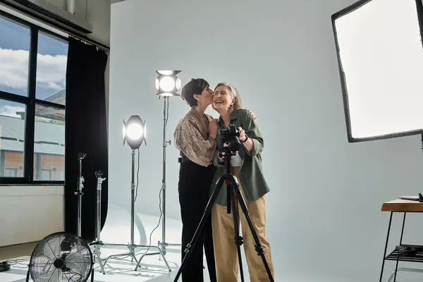 Фотограф запечатлел лесбийскую пару средних лет целующуюся в фотостудии. — стоковое фото