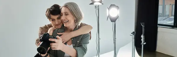 Una mujer de mediana edad mirando fotos en cámara en un estudio fotográfico. — Stock Photo