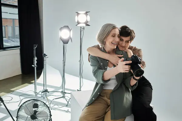 A middle-aged lesbian couple in a photo studio looking at camera — Stock Photo