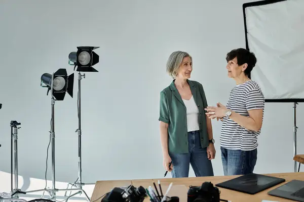 Una pareja de lesbianas de mediana edad posa en un estudio moderno profesional - foto de stock