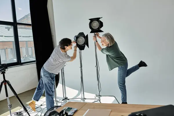 Hombre y mujer de mediana edad posan en un estudio fotográfico profesional. - foto de stock