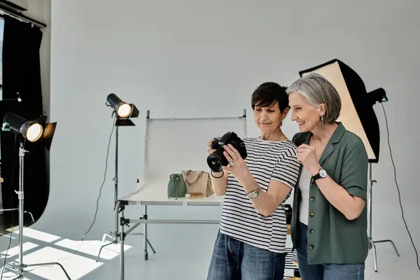 Женщина в фотостудии делает снимок, используя камеру, в совместной и творческой обстановке. — стоковое фото