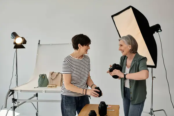 Lgbt couple in a professional photo studio, working together with a camera. — Stock Photo