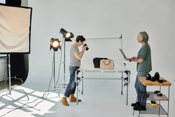 Middle-aged women taking photo of bags in a professional photo studio. — Stock Photo