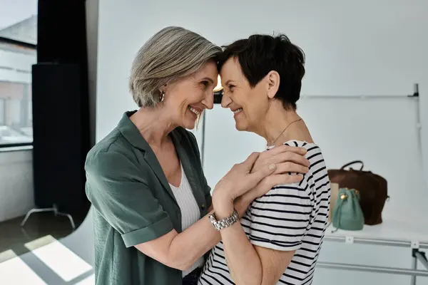 Two middle-aged women, a lesbian couple, stand side by side in a modern photo studio. — Stock Photo