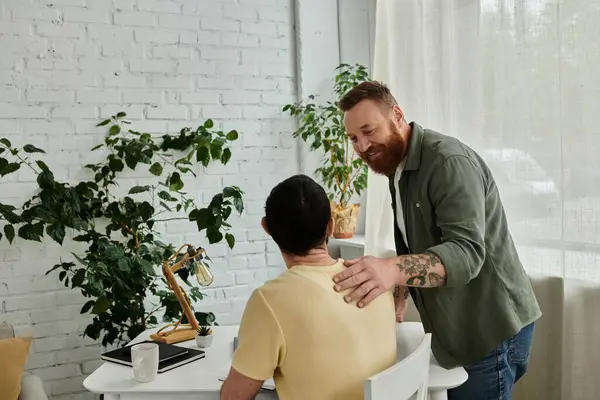 A bearded man in a green shirt talks to a man in a yellow shirt, a gay couple spending quality time together. — Stock Photo