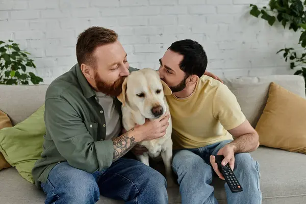 Ein bärtiger Mann hält liebevoll einen Labrador, während er es sich auf einer gemütlichen Couch im Wohnzimmer gemütlich macht. — Stockfoto