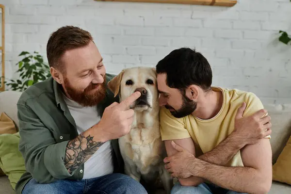 A bearded man relaxes on a couch next to his Labrador in a cozy living room, enjoying quality time together. — Stock Photo