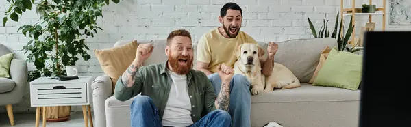 Um homem e seu cão labrador sentam-se em um sofá, assistindo a um jogo esportivo, personificando amor, companheirismo e relaxamento. — Fotografia de Stock