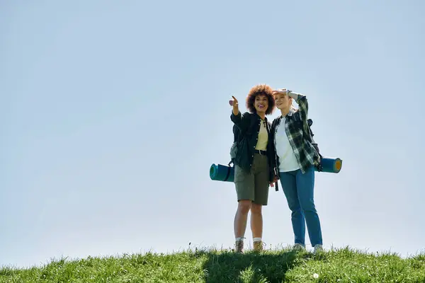 A young lesbian couple hikes through the wilderness, enjoying a sunny day together. — Stock Photo