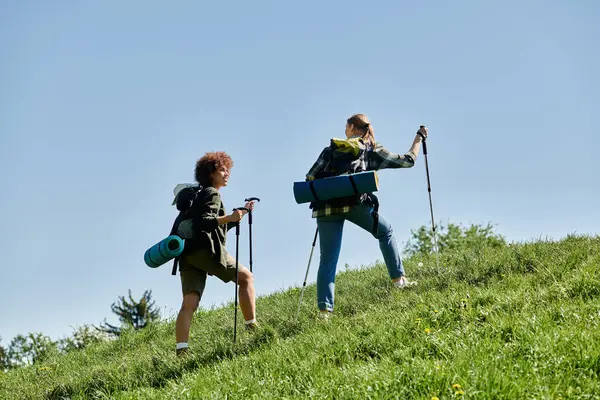 Due giovani donne, una coppia lesbica, camminano attraverso un paesaggio selvaggio, godendosi l'aria aperta insieme. — Foto stock