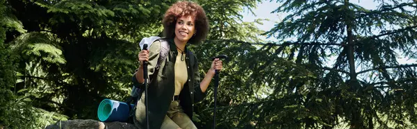 A young woman enjoys a sunny summer day hiking through a lush green forest. — Stock Photo