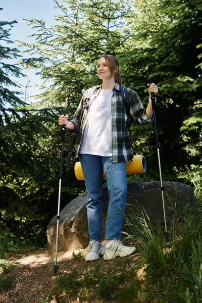 Eine junge Frau lächelt, als sie an einem sonnigen Sommertag durch den Wald wandert. — Stockfoto