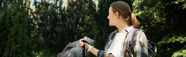 A young woman hikes through a dense forest, enjoying a sunny summer day. — Stock Photo
