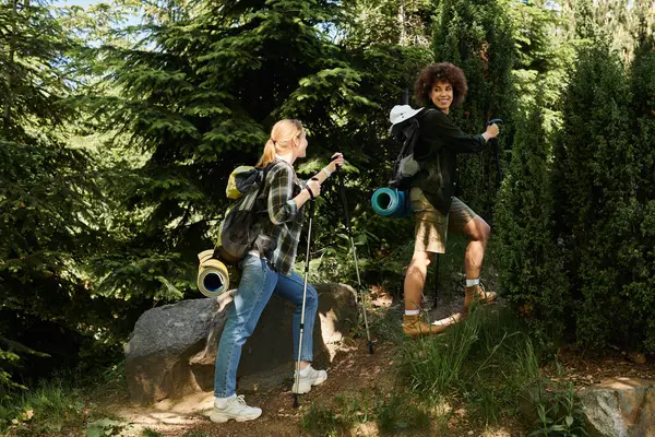 A lesbian couple hikes through a lush forest, enjoying quality time outdoors. — Stock Photo