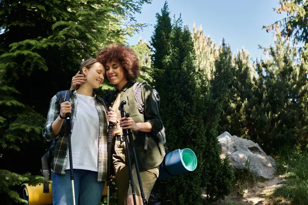 Una giovane coppia lesbica si ferma durante un'escursione, condividendo un momento tenero nella natura selvaggia. — Foto stock