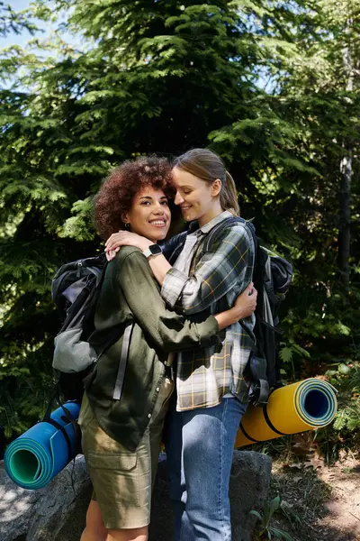 Due giovani donne, una coppia lesbica, si abbracciano su un sentiero nel deserto. — Foto stock