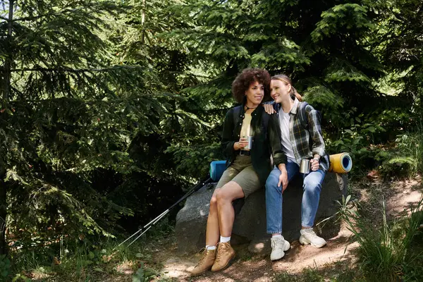 Una coppia lesbica gode di una pausa dalla loro escursione nella foresta. — Foto stock