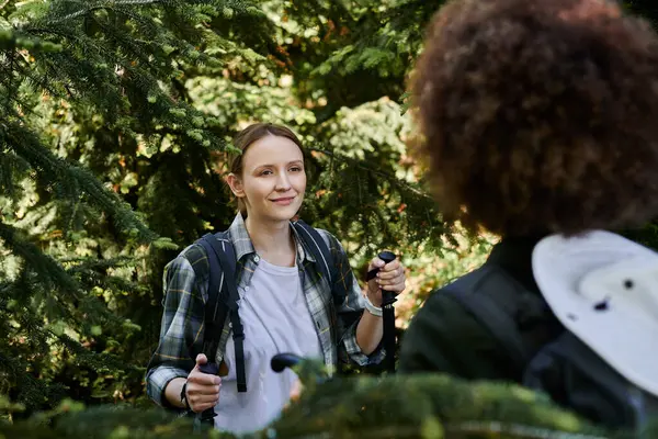 Two young women, a lesbian couple, hike through a forest, enjoying the outdoors and each others company. — Stock Photo