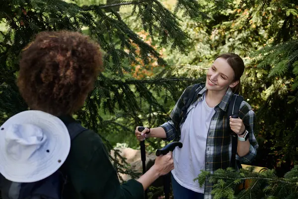 A young lesbian couple hikes through a lush forest, smiling and enjoying their time together. — Stock Photo