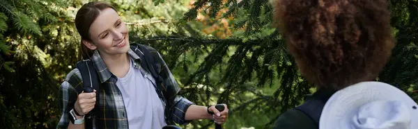Una giovane coppia lesbica cammina attraverso una lussureggiante foresta verde, godendo di tempo di qualità insieme all'aperto. — Foto stock
