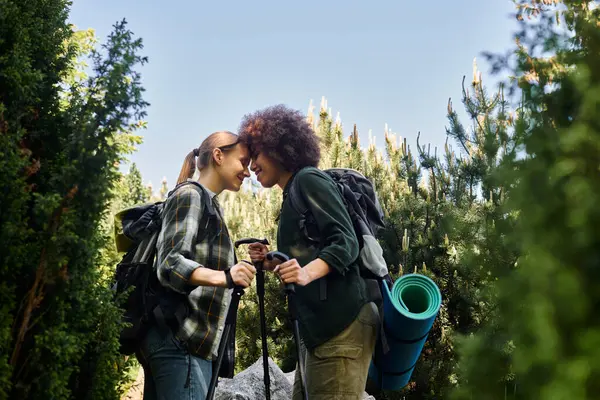 Due giovani donne, una coppia lesbica, camminano attraverso una zona boscosa, godendosi l'aria aperta insieme. — Foto stock