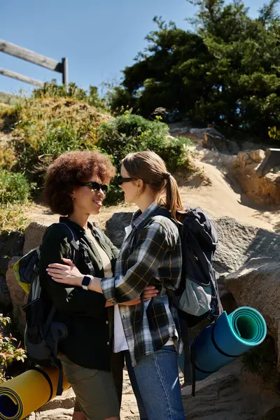 A young lesbian couple embraces in a scenic outdoor setting. — Stock Photo