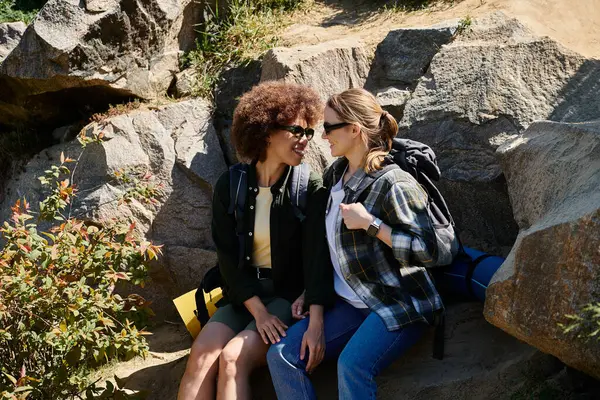 Two young women, hiking partners and lovers, take a break to enjoy the view and each others company. — Stock Photo