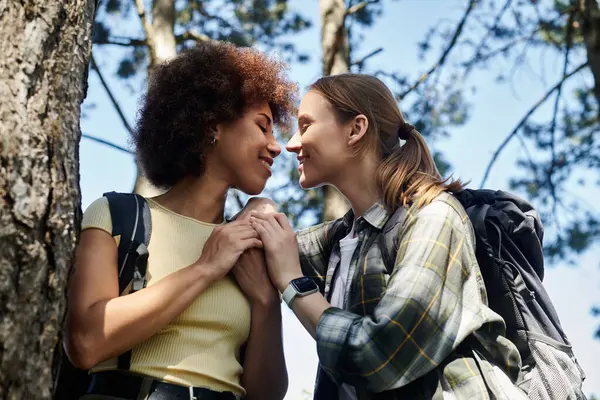 A young lesbian couple enjoys a romantic moment while hiking through a lush forest. — Stock Photo