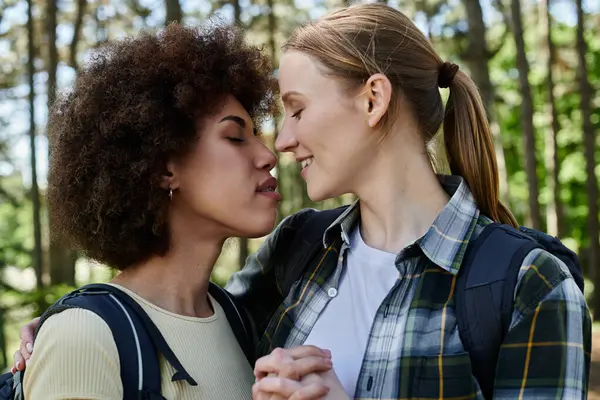 Two young women, a lesbian couple, enjoy a moment of intimacy during a hike in the wilderness. — Stock Photo