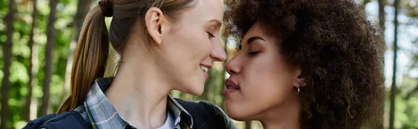 A young lesbian couple enjoys a peaceful hike together, their faces illuminated by the love they share. — Stock Photo