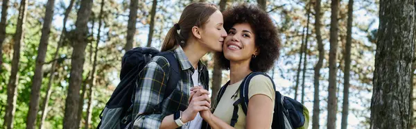 Um jovem casal lésbico compartilha um momento terno durante uma caminhada por uma área arborizada. — Fotografia de Stock