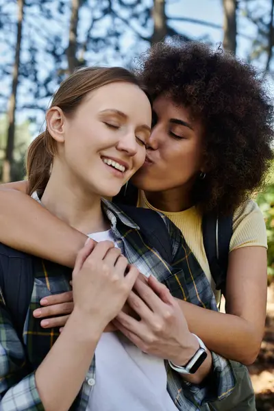 A young lesbian couple shares a tender moment in a wooded setting, showcasing their love and connection. — Stock Photo