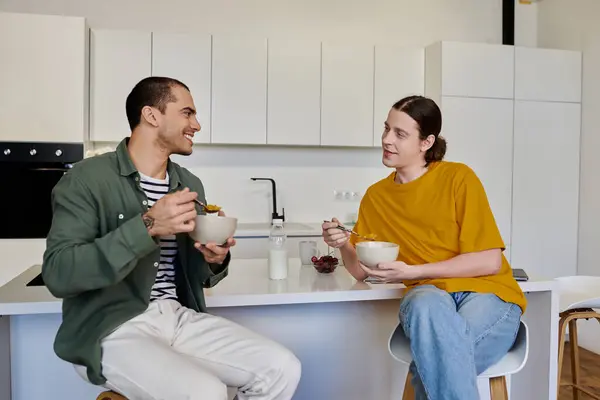 A young gay couple enjoys a relaxed breakfast together in their modern apartment. — Stock Photo