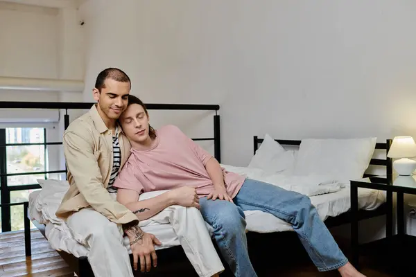 Um jovem casal gay passa uma tarde tranquila juntos, relaxando em uma cama em um apartamento moderno. — Fotografia de Stock