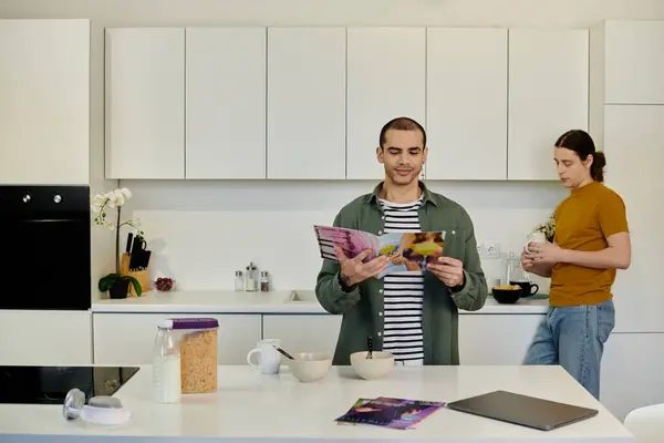 A young gay couple in casual attire enjoys a relaxed morning together in their modern apartment. — Stock Photo