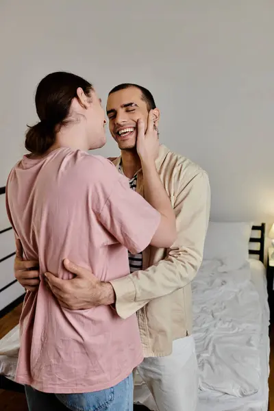 A young gay couple embraces in their modern apartment, radiating love and happiness. — Stock Photo