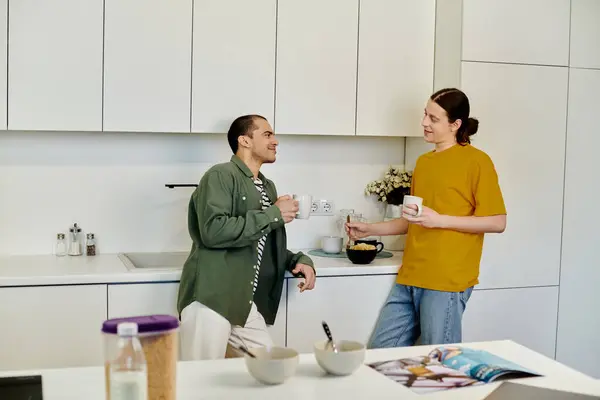 Um jovem casal gay desfruta de uma manhã casual em seu apartamento moderno, compartilhando café e conversa. — Fotografia de Stock